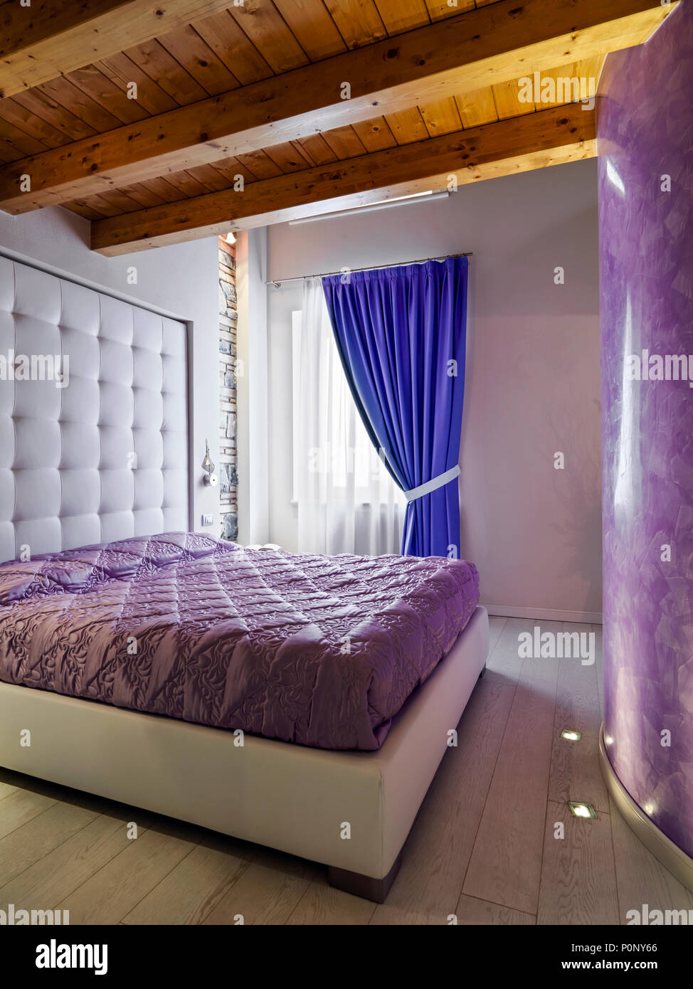 Contemporanee camere da letto interno con soffitto in legno e tende blu Foto Stock
