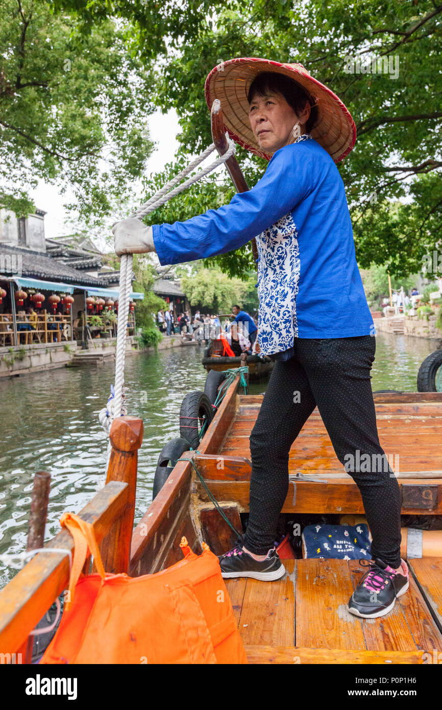 Suzhou, Jiangsu, Cina. Donna di mezza età barca a remi per i visitatori su un canale in Tongli antica cittadina nei pressi di Suzhou. Foto Stock