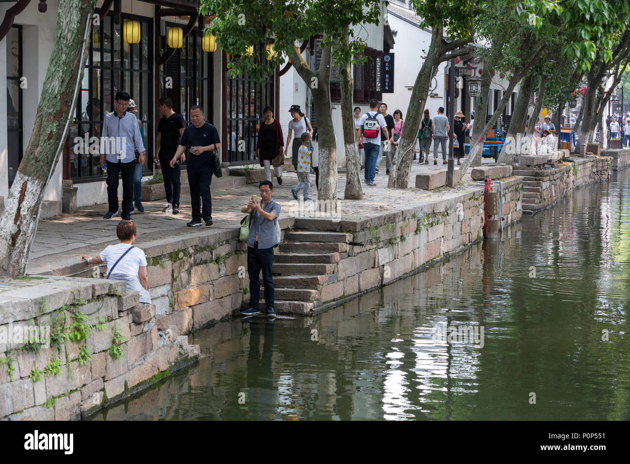 Suzhou, Jiangsu, Cina. I visitatori a piedi lungo Canal passando attraverso Tongli antica cittadina nei pressi di Suzhou. Un week-end popolare destinazione turistica. Foto Stock