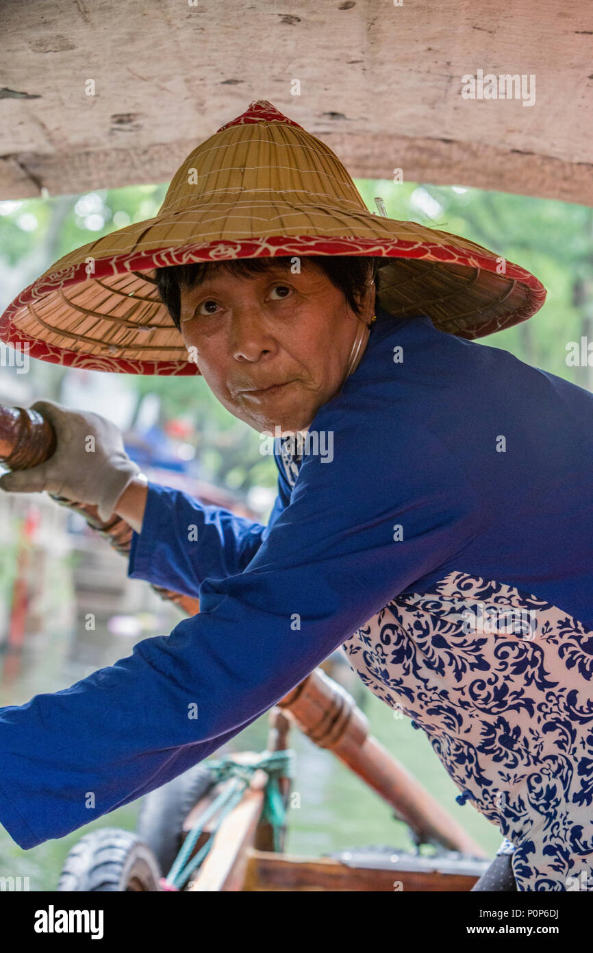 Suzhou, Jiangsu, Cina. Donna di mezza età barca a remi per i visitatori su un canale in Tongli antica cittadina nei pressi di Suzhou. Foto Stock