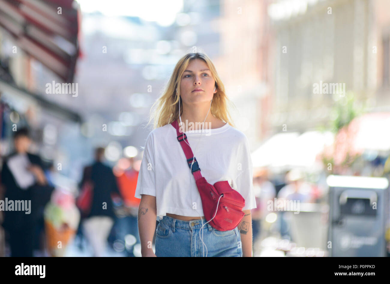 Bionda donna svedese camminando giù Drottninggatan street, a Stoccolma Foto Stock