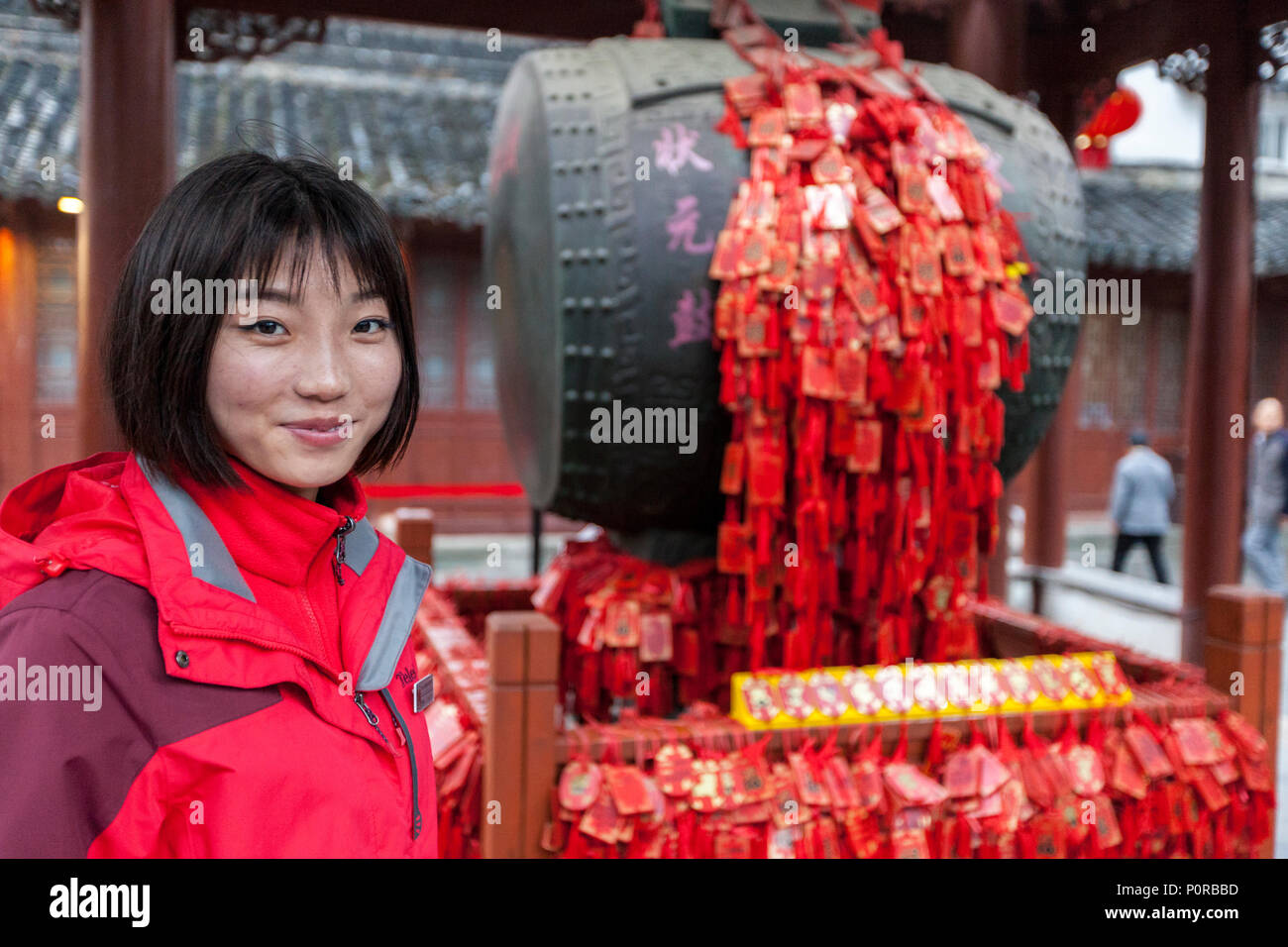 Nanjing, Jiangsu, Cina. Giovane donna nel Padiglione del tamburo del tempio confuciano complesso. Tassles rosso e i tag sono preghiere per la buona fortuna. Foto Stock