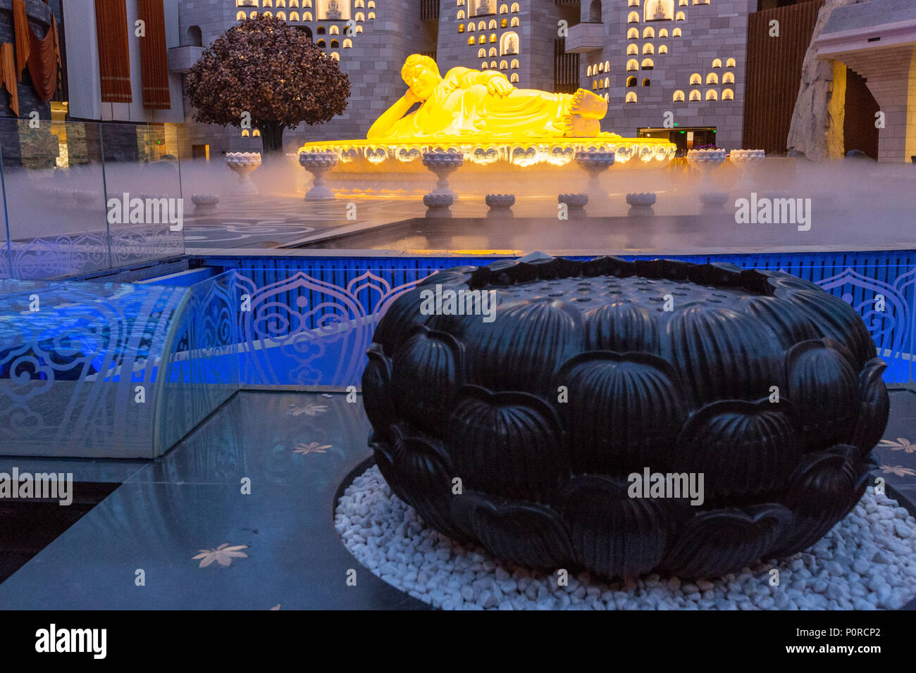 Nanjing, Jiangsu, Cina. Scultura di Buddha in Usnisa Palace, Niushou Montagna. Lotus scultura in primo piano. Foto Stock