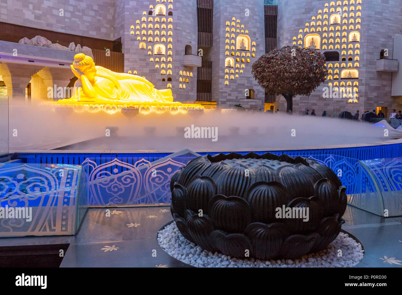 Nanjing, Jiangsu, Cina. Scultura di Buddha in Usnisa Palace, Niushou Montagna. Lotus scultura in primo piano. Foto Stock