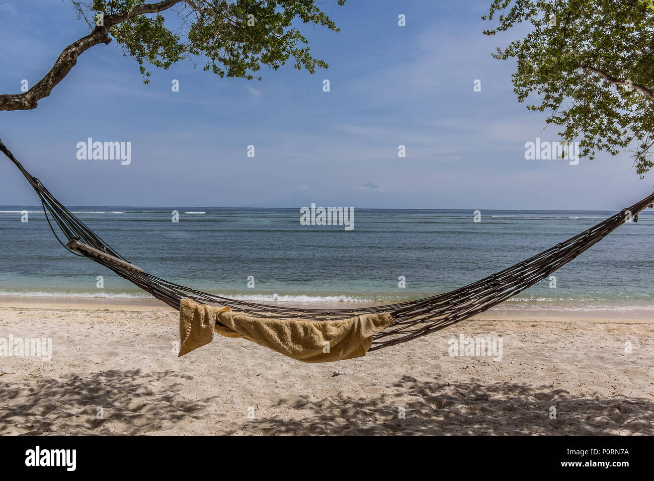 Un asciugamano in un vuoto di amaca, oscillare sulla spiaggia tra due alberi , vicino al mare tropicale, Gili Trawngan, Indonesia, 25 aprile 2018 Foto Stock