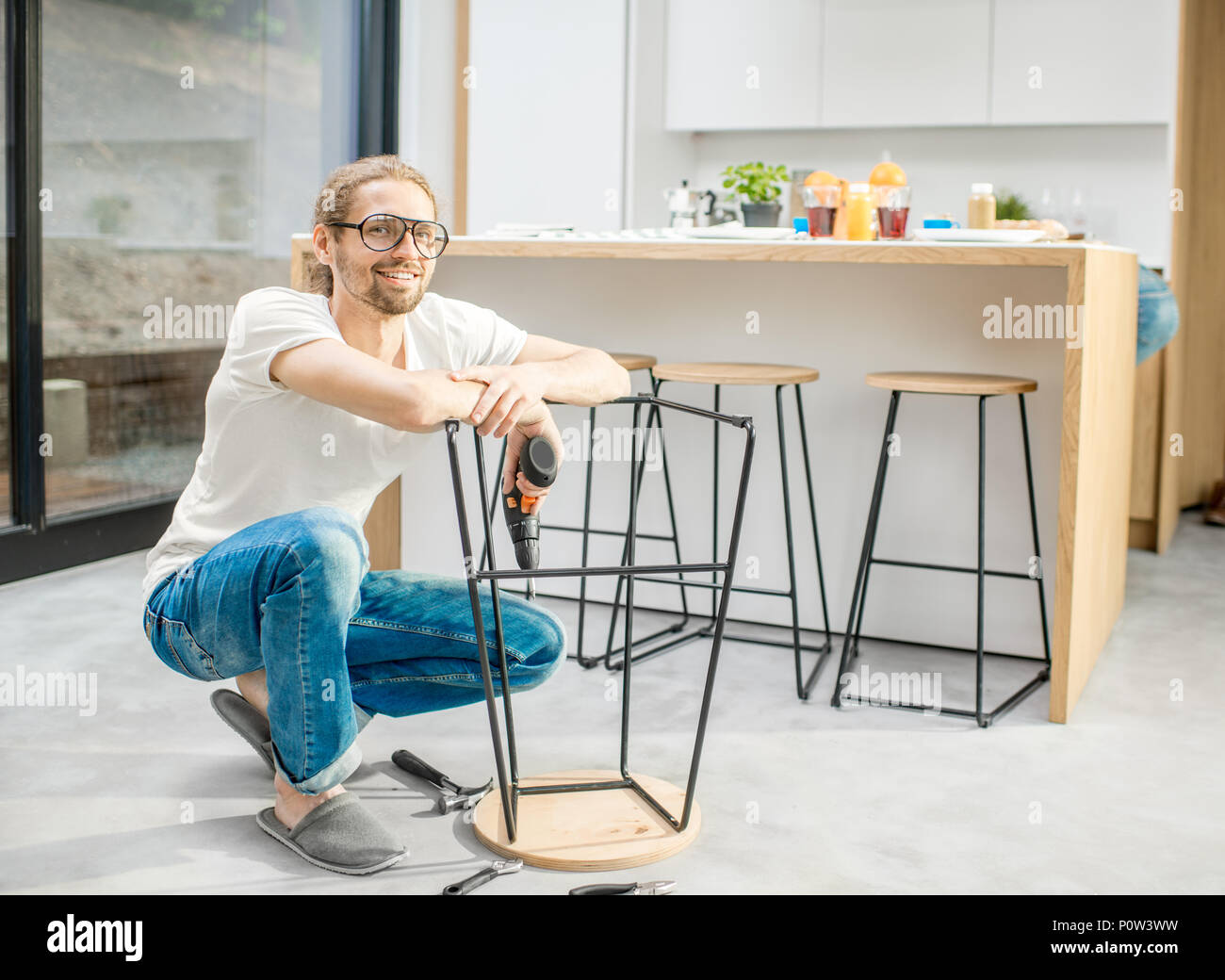 Uomo sedia di assemblaggio in appartamento Foto Stock