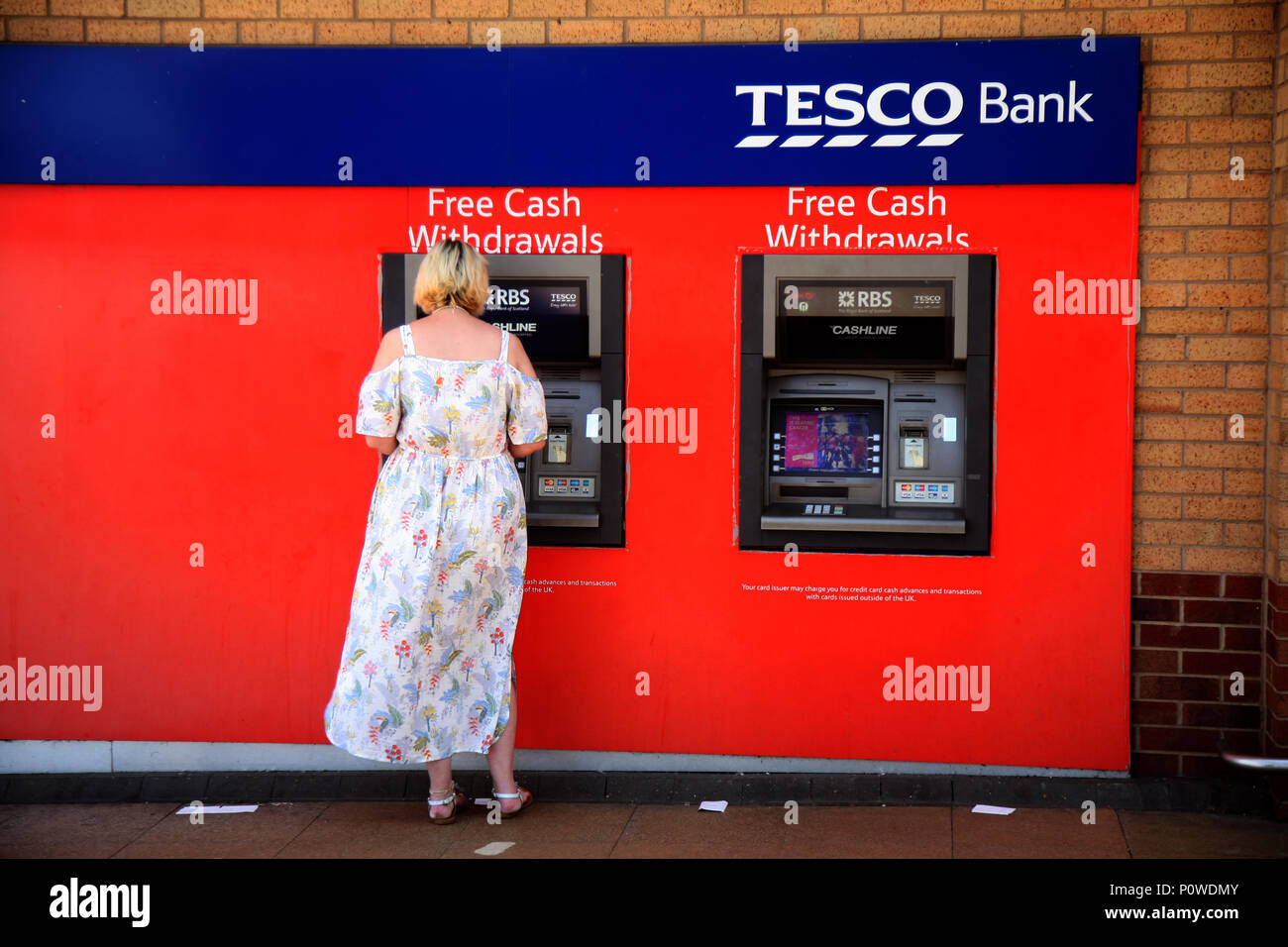 Lady in corrispondenza di una delle due macchine in contanti presso il sito Tesco a Undergate Rd, Dinnington, Sheffield S25 2PF Foto Stock