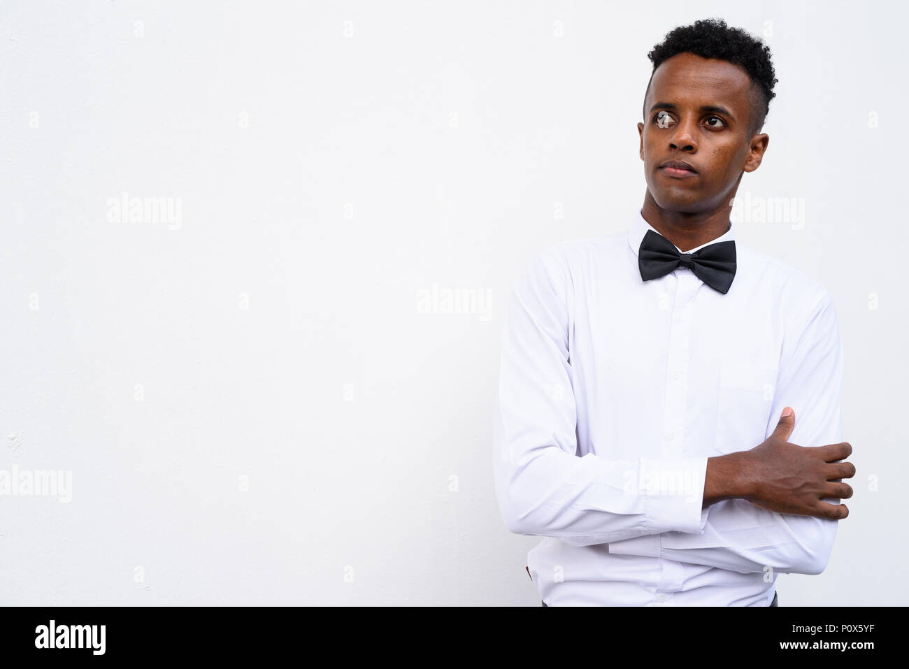 Bel giovane imprenditore africani che indossa il filtro bow tie contro white Foto Stock