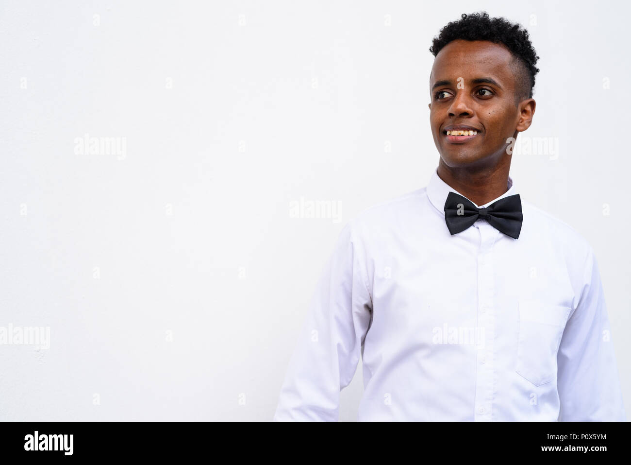 Bel giovane imprenditore africani che indossa il filtro bow tie contro white Foto Stock