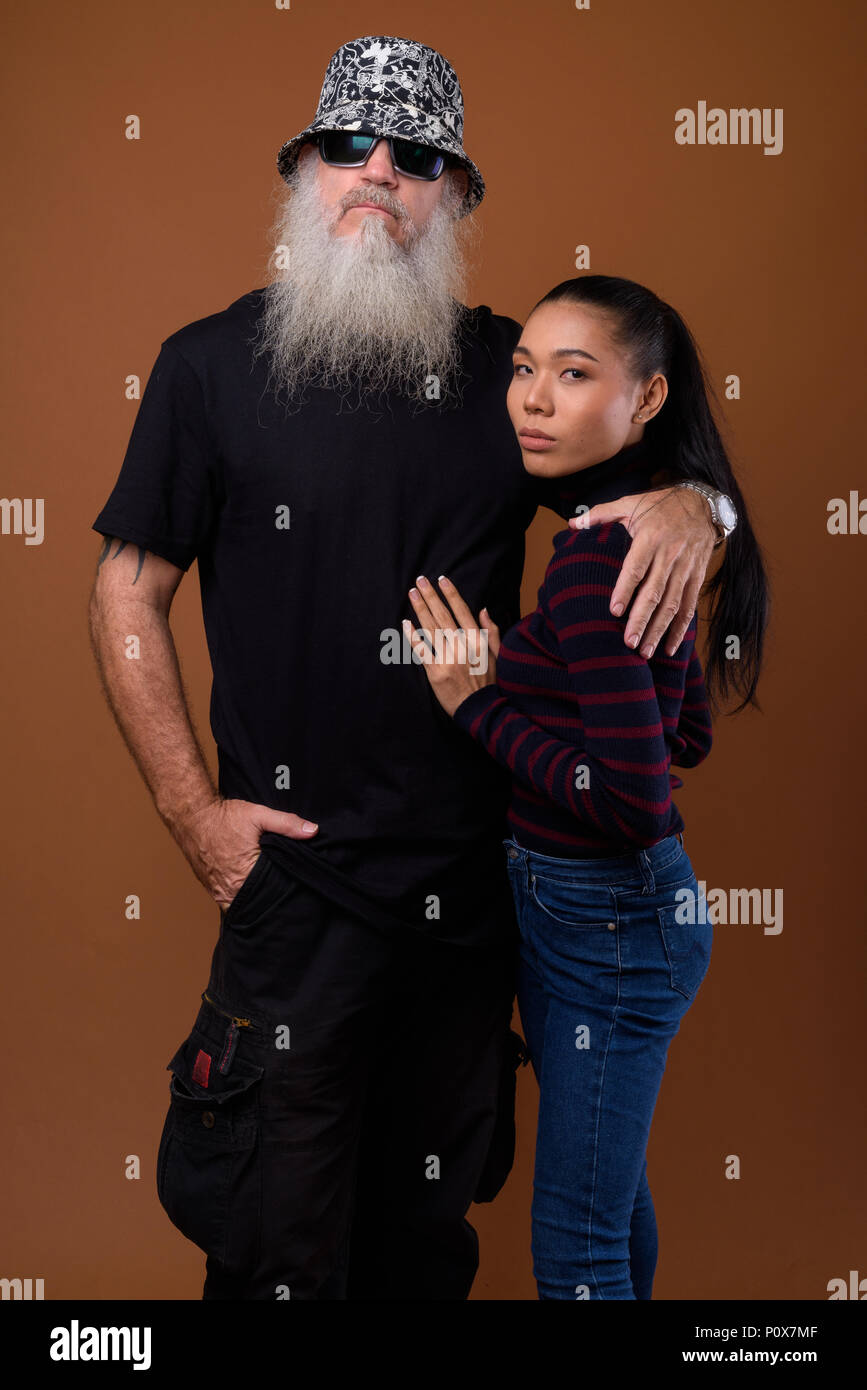 Coppia barbuto uomo calvo con giovani asiatici transgender donna Foto Stock