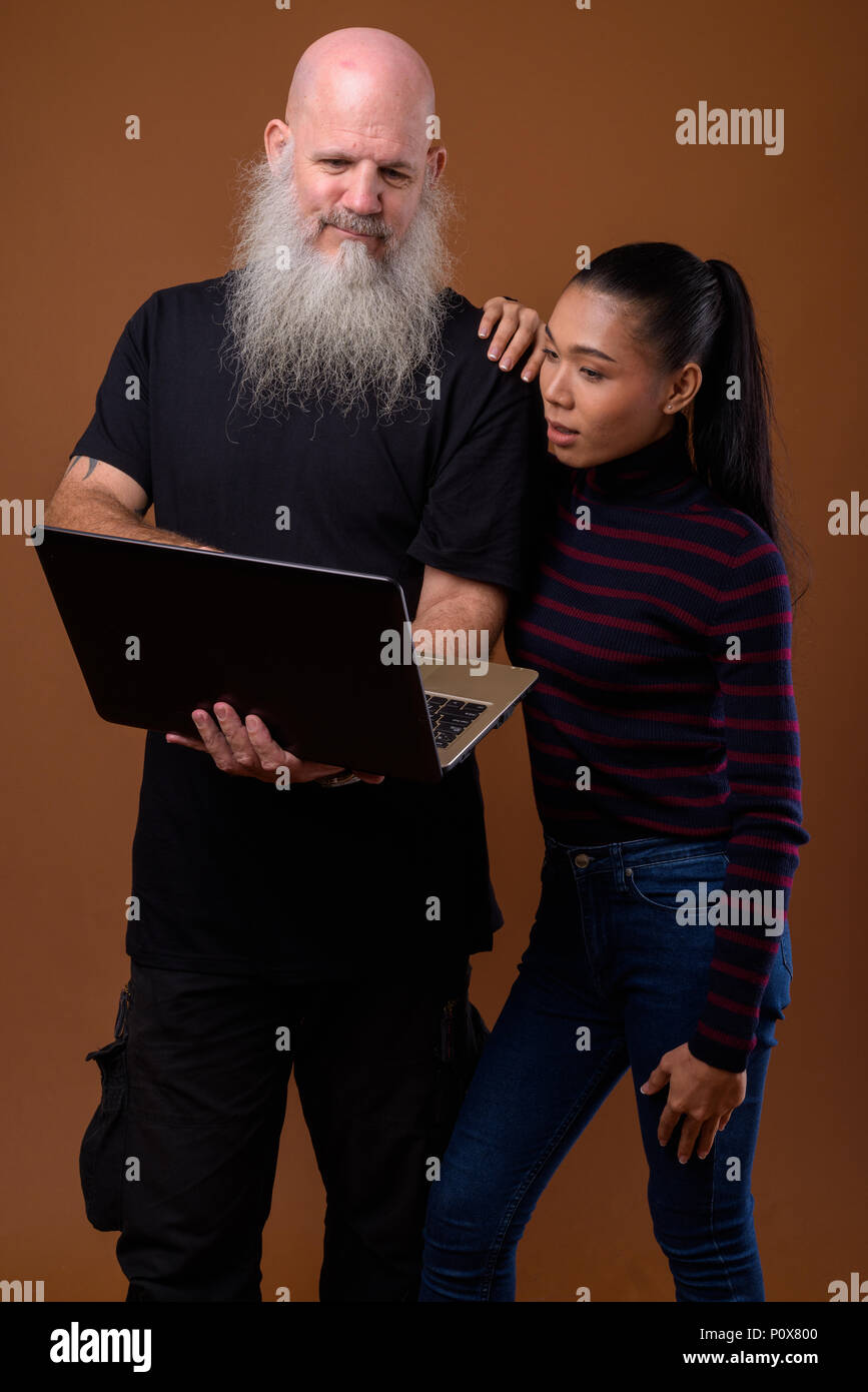 Coppia barbuto uomo calvo con giovani asiatici transgender donna Foto Stock