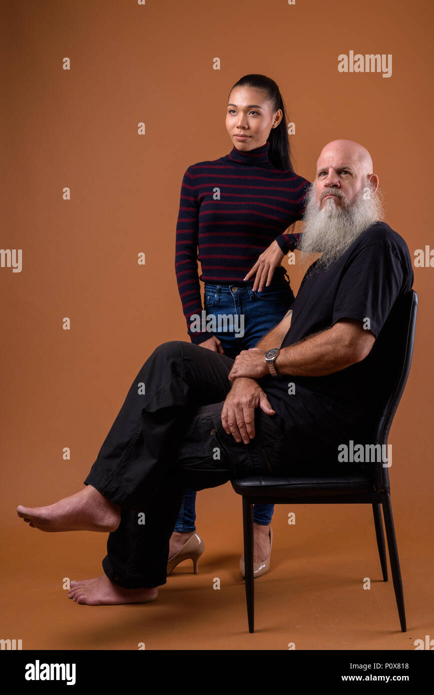Coppia barbuto uomo calvo con giovani asiatici transgender donna Foto Stock