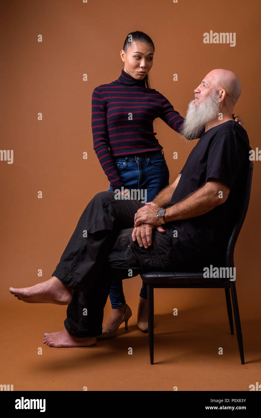 Coppia barbuto uomo calvo con giovani asiatici transgender donna Foto Stock