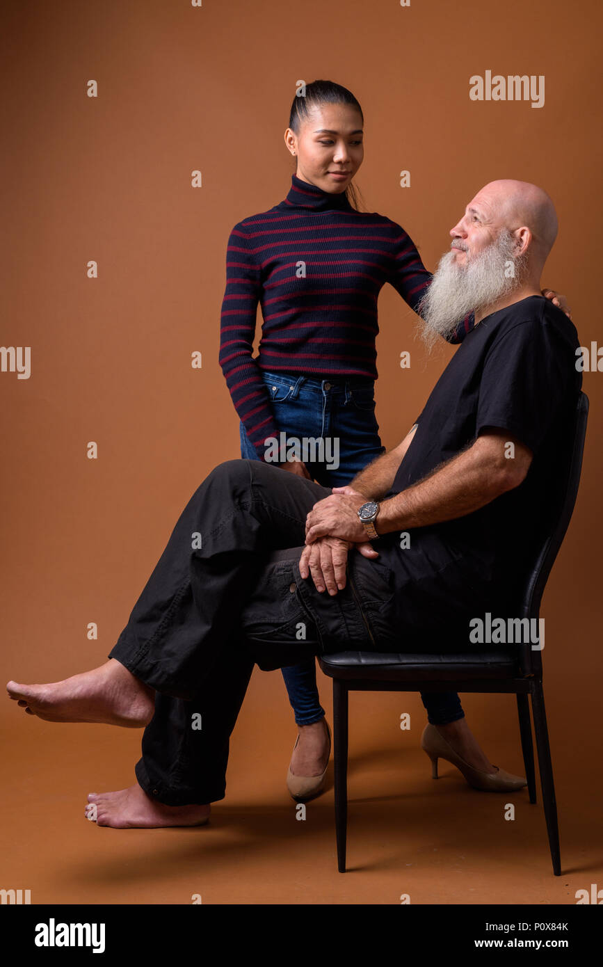 Coppia barbuto uomo calvo con giovani asiatici transgender donna Foto Stock