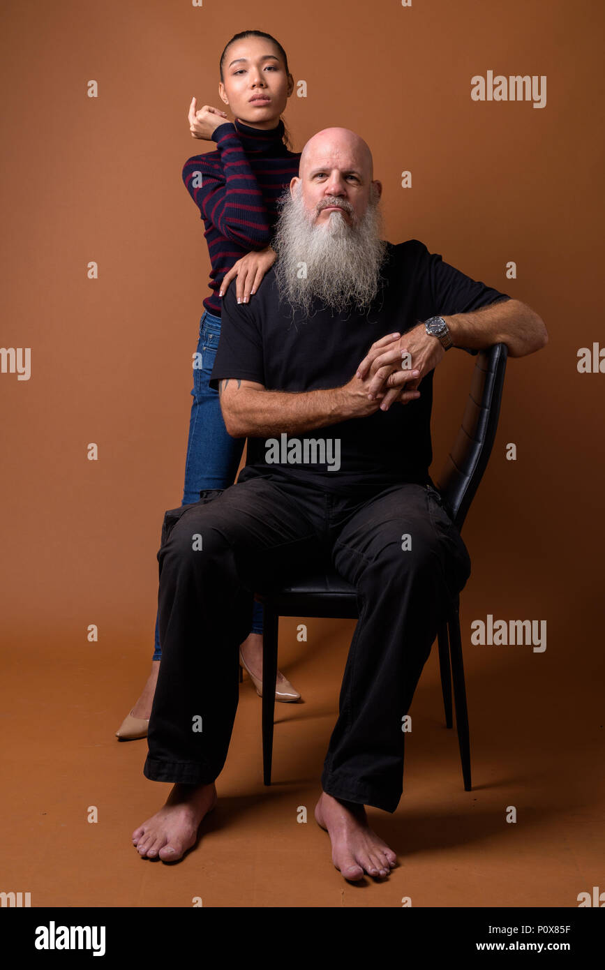 Coppia barbuto uomo calvo con giovani asiatici transgender donna Foto Stock