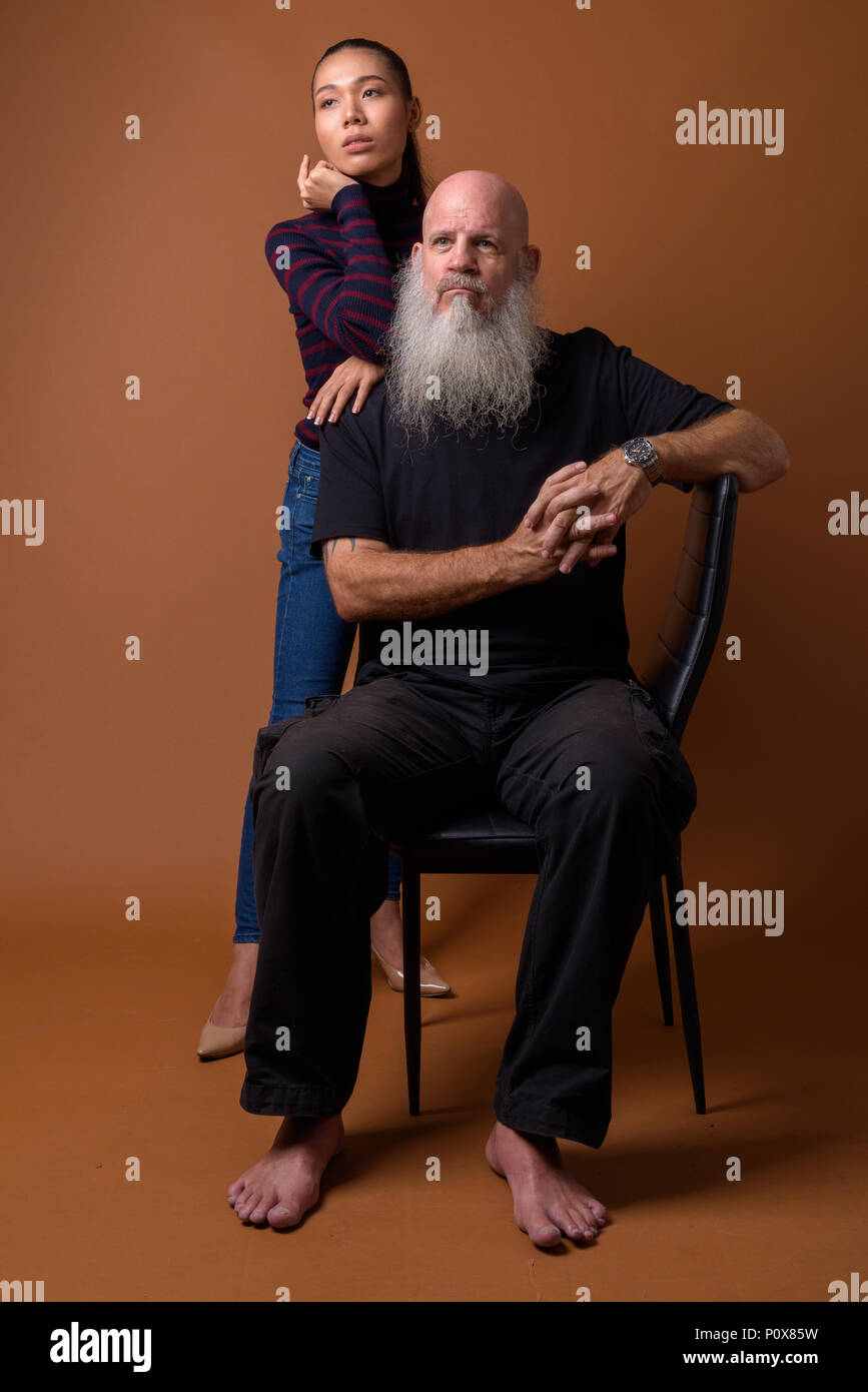 Coppia barbuto uomo calvo con giovani asiatici transgender donna Foto Stock