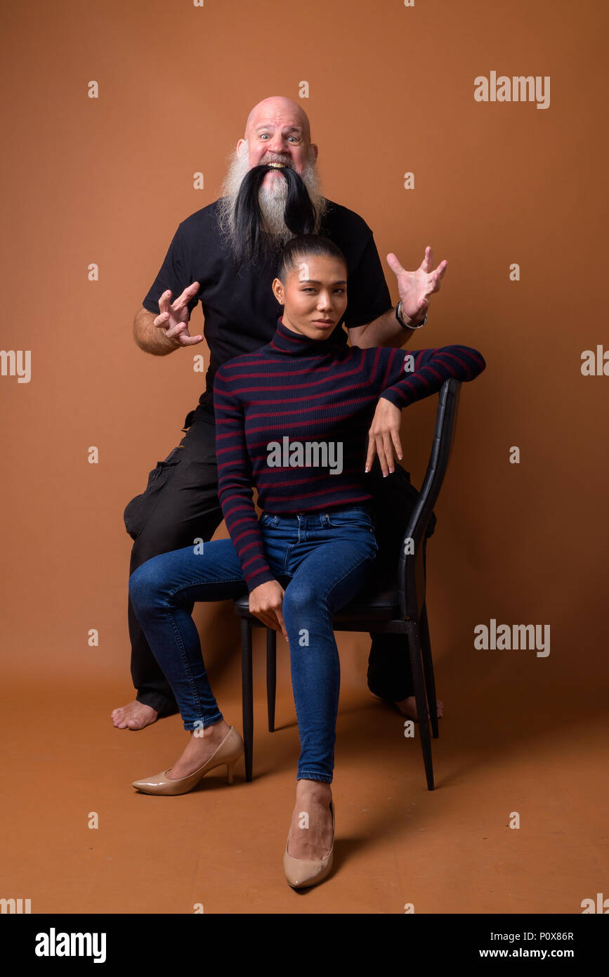 Coppia barbuto uomo calvo con giovani asiatici transgender donna Foto Stock