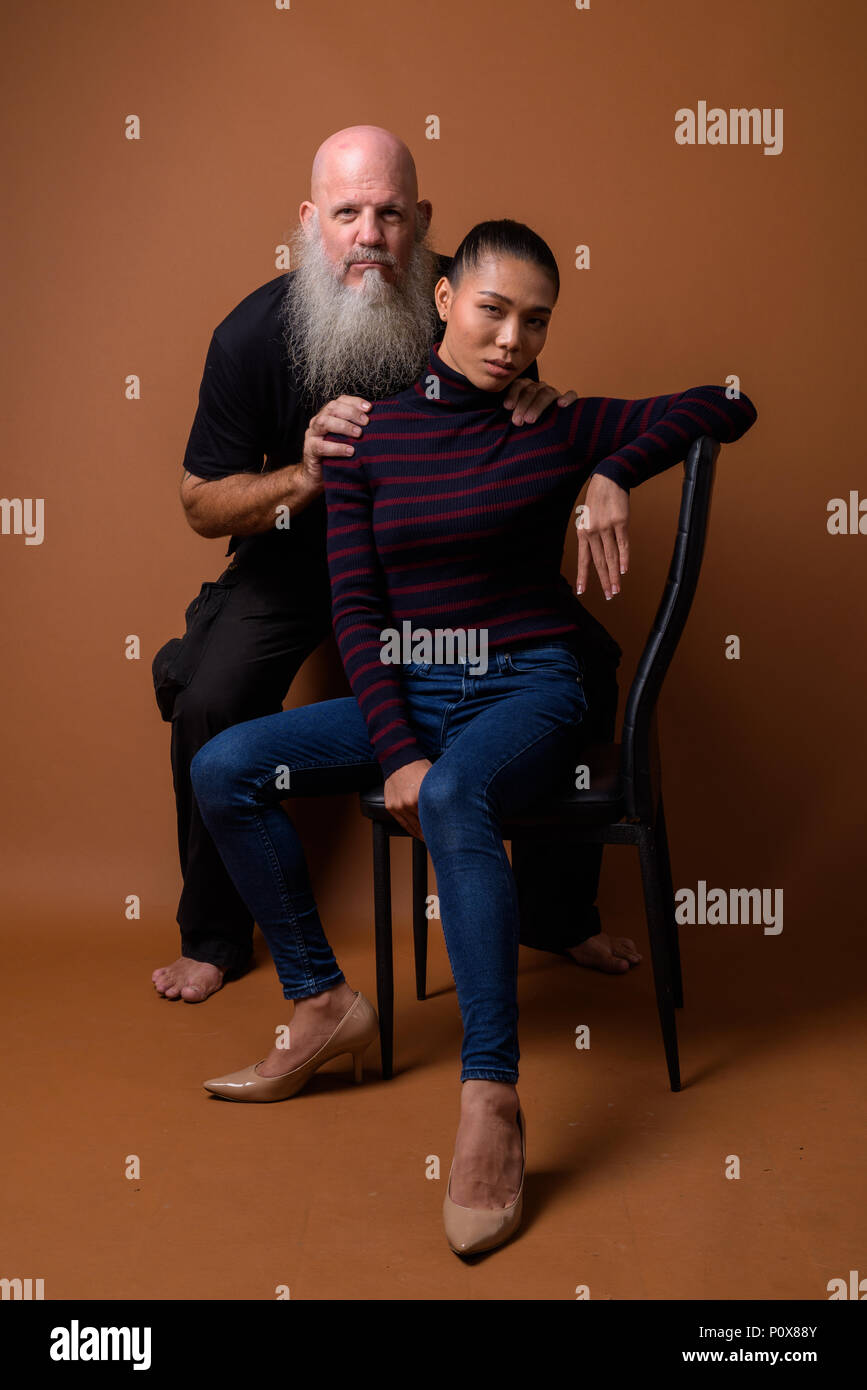 Coppia barbuto uomo calvo con giovani asiatici transgender donna Foto Stock