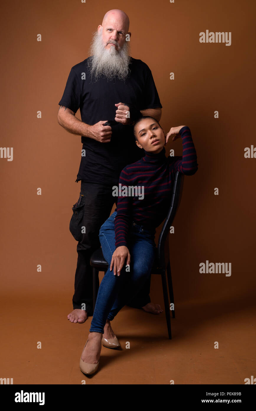 Coppia barbuto uomo calvo con giovani asiatici transgender donna Foto Stock