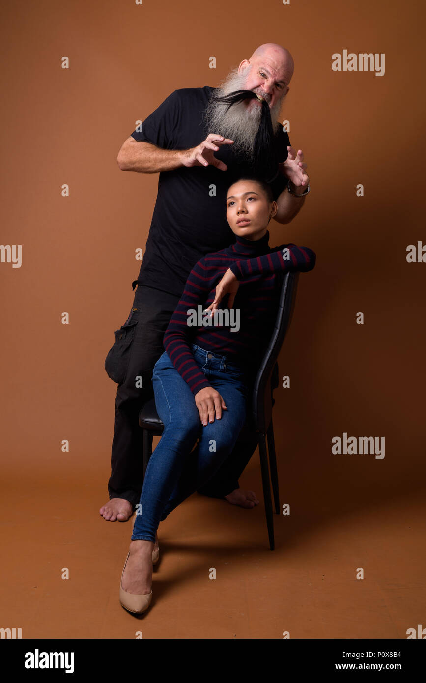 Coppia barbuto uomo calvo con giovani asiatici transgender donna Foto Stock