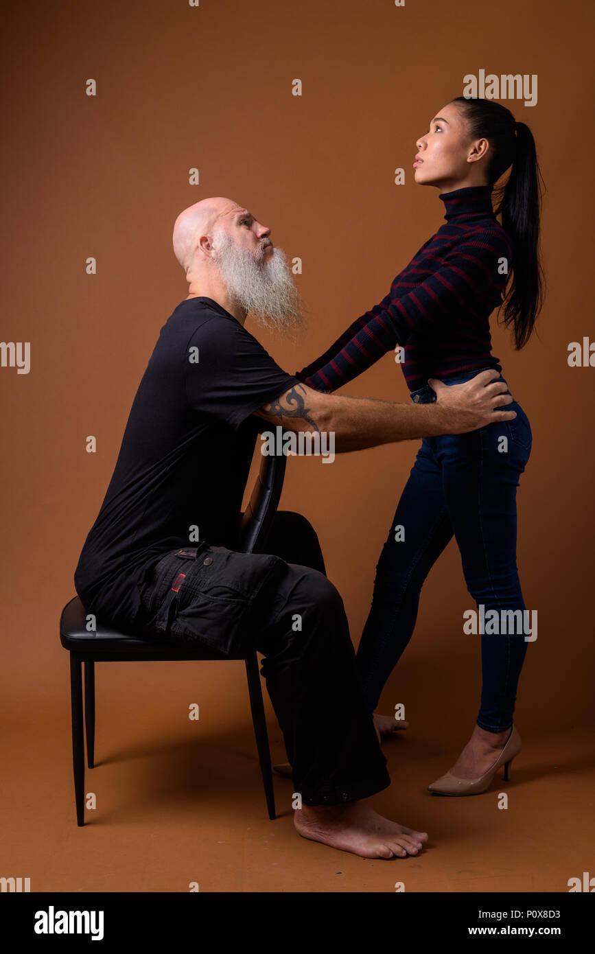 Coppia barbuto uomo calvo con giovani asiatici transgender donna Foto Stock