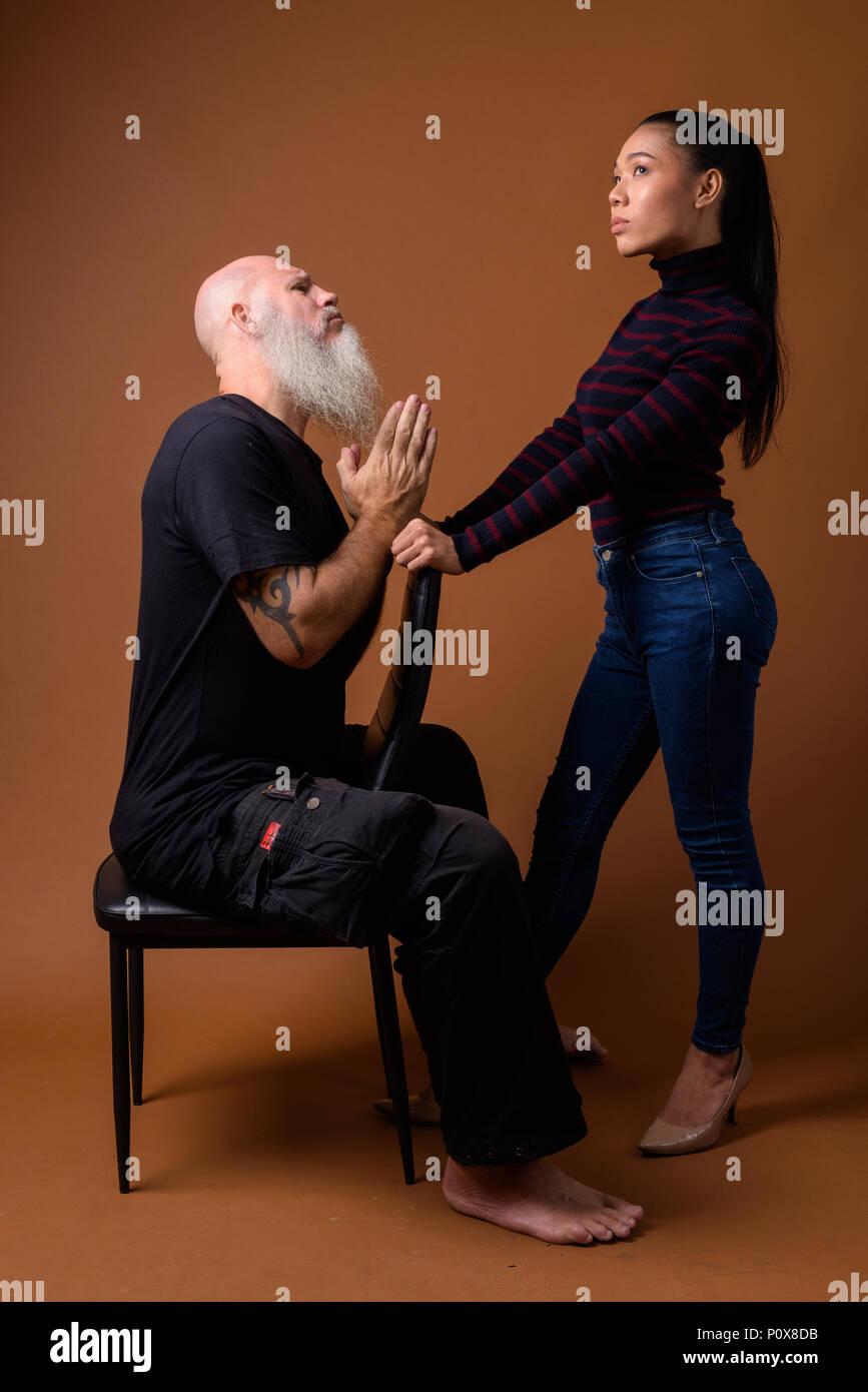 Coppia barbuto uomo calvo con giovani asiatici transgender donna Foto Stock