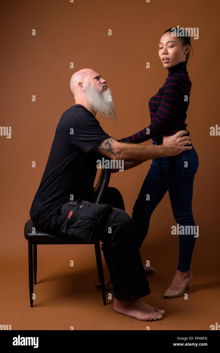 Coppia barbuto uomo calvo con giovani asiatici transgender donna Foto Stock