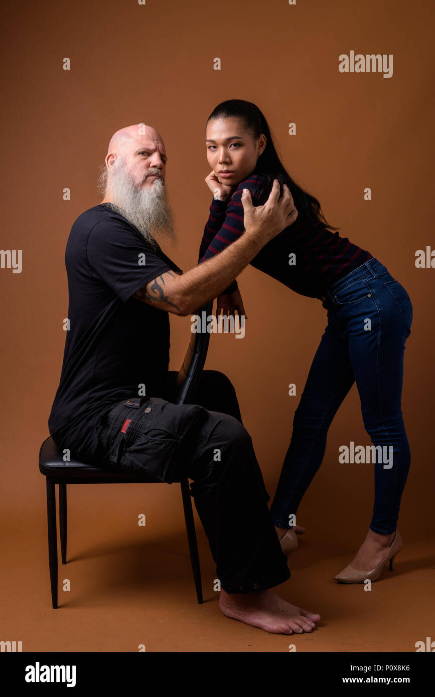 Coppia barbuto uomo calvo con giovani asiatici transgender donna Foto Stock