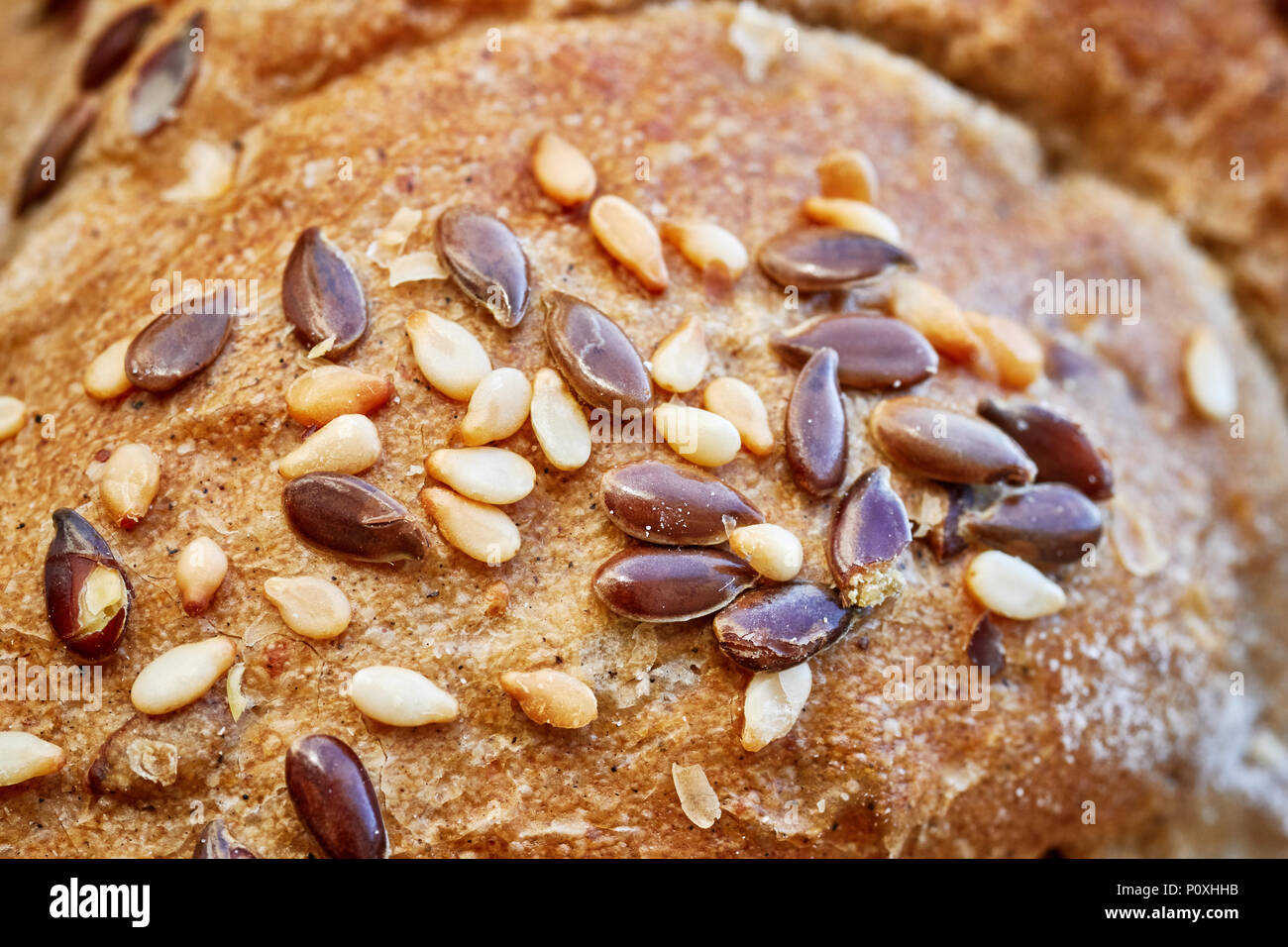 Chiudere l immagine di un grano intero crosta di pane con lino e i semi di sesamo, il fuoco selettivo. Foto Stock