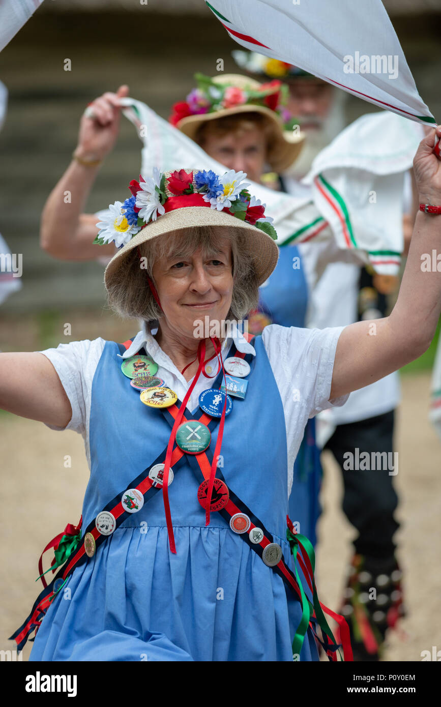 Femmina ballerini morris indossando cappelli estivi coperto di fiori e  indossando i costumi tradizionali di danza con i fazzoletti da naso o da  taschino durante una morris dancing evento nel West Sussex,