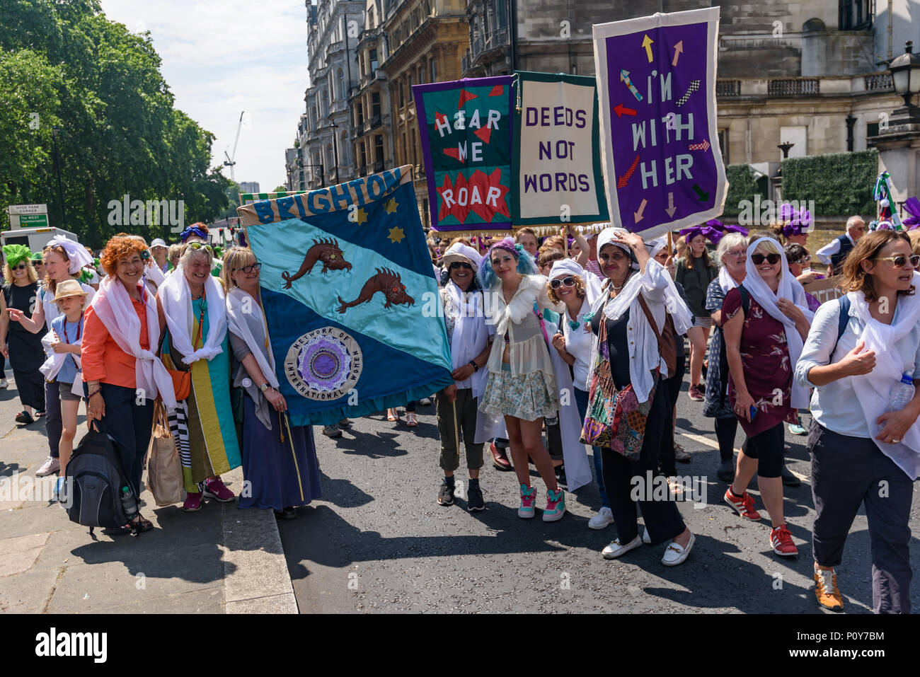 Londra, Regno Unito. Il 10 giugno 2018. Le donne da Brighton posano per una fotografia. Le donne indossavano viola, il bianco e il verde il velo a fare fino a tre trefoli di una grande processione attraverso la marcatura di Londra 100 anni poiché molte donne le donne hanno ottenuto il diritto di voto. La legge del 1918 ha dato il voto per la prima volta per tutti gli uomini su 21, ma le donne hanno dovuto essere over 30 e soddisfare un requisito di proprietà. Era un altro dieci anni prima che tutte le donne sopra i 21 potrebbe votare. Peter Marshall / Alamy Live News Foto Stock