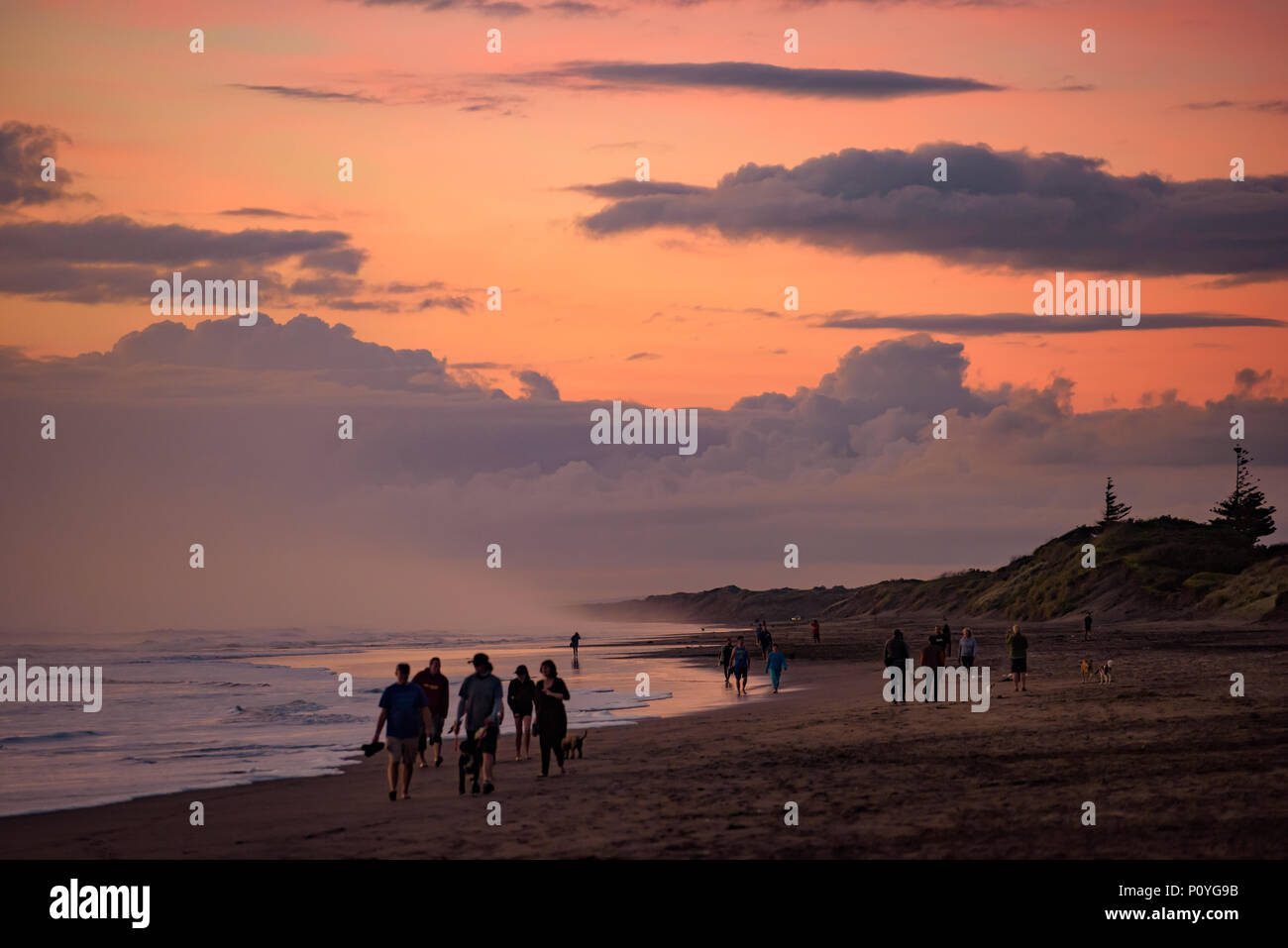 Muriwai spiaggia al tramonto con le nuvole colorate, Nuova Zelanda Foto Stock