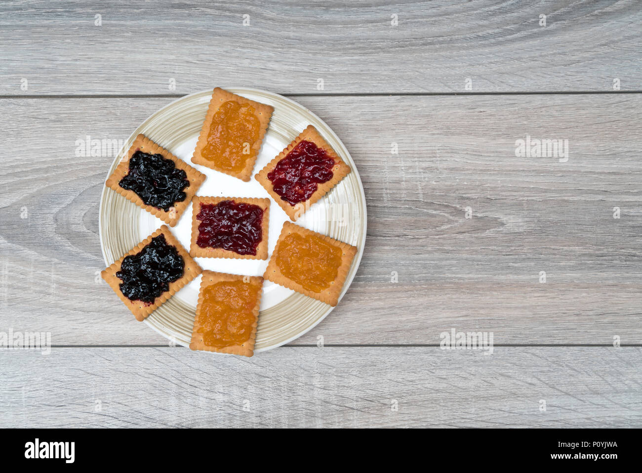 Un biscotto con la marmellata in una mano Foto Stock