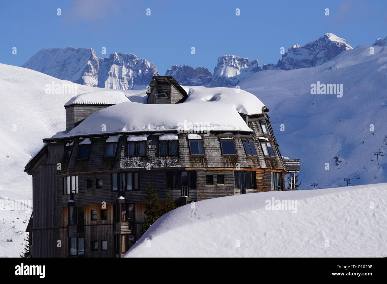 Architettura inusuale della stazione sciistica di Avoriaz, Francia su una bella e soleggiata giornata invernale con le Alpi in background Foto Stock