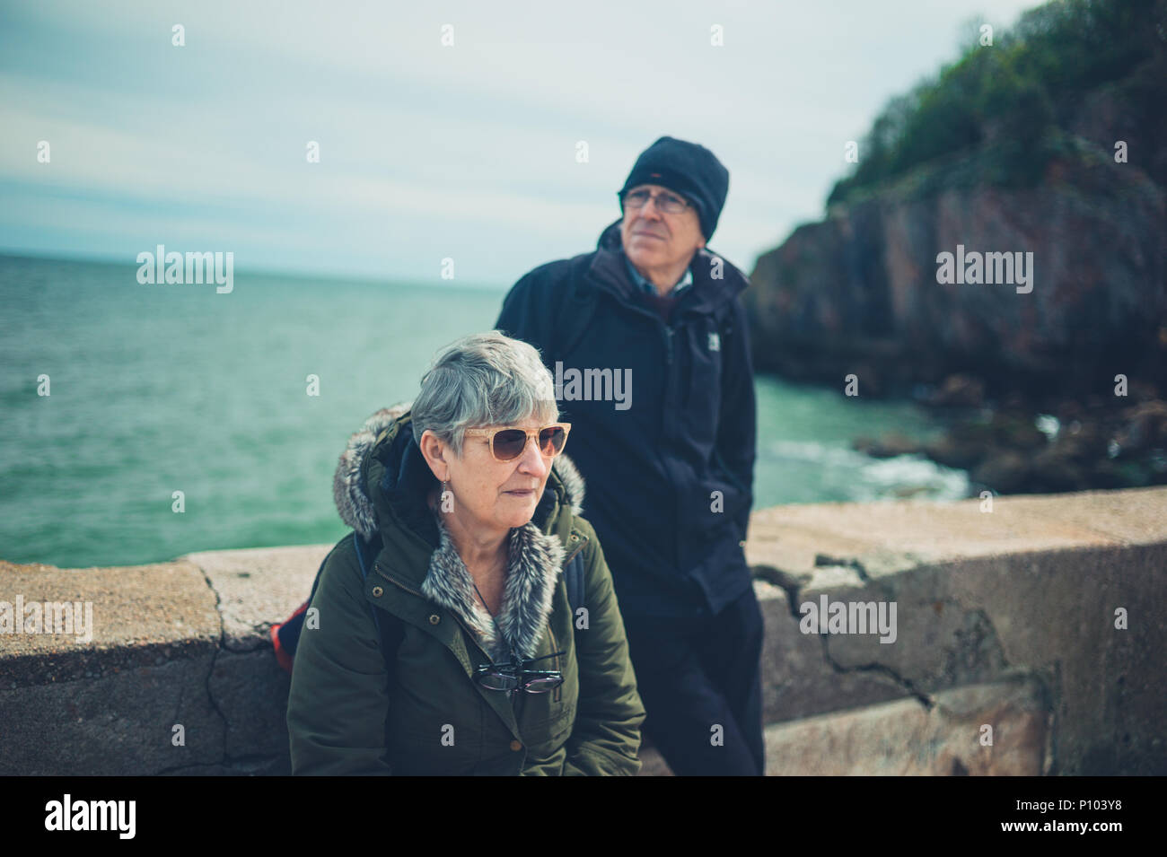 Una coppia senior è rilassante e godendo il pensionamento in riva al mare Foto Stock