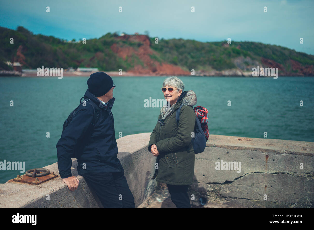 Una coppia senior è rilassante e godendo il pensionamento in riva al mare Foto Stock