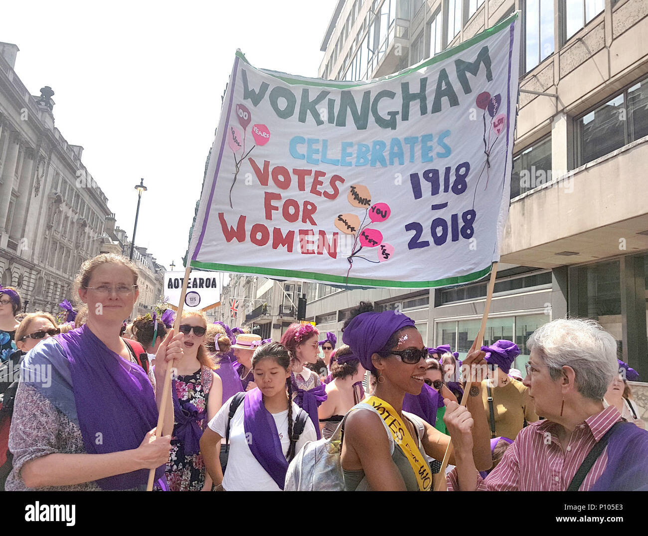 Un gruppo di amici di Wokingham si è recato per unirsi alla marcia attraverso il centro di Londra vestito di verde, viola e bianco - i colori del movimento suffragette per aiutare i loro figli a capire ciò che è accaduto 100 anni fa e che non possono dare per scontato le cose che hanno ora. Foto Stock