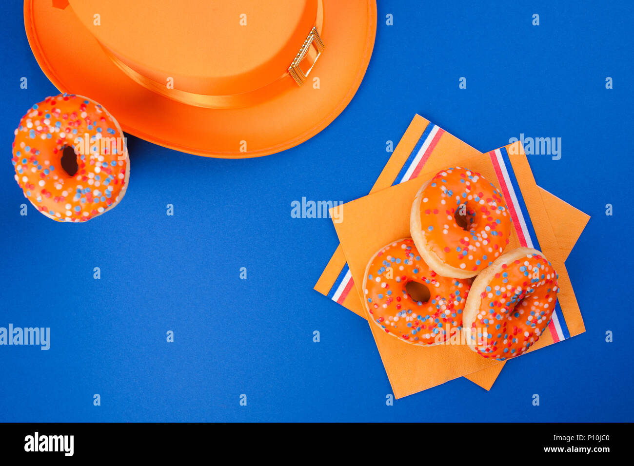 Dolci per la festa del re. Decorazione di colore arancione. Il carnevale nei Paesi Bassi. Sfondo blu e lo spazio per il testo. Foto Stock