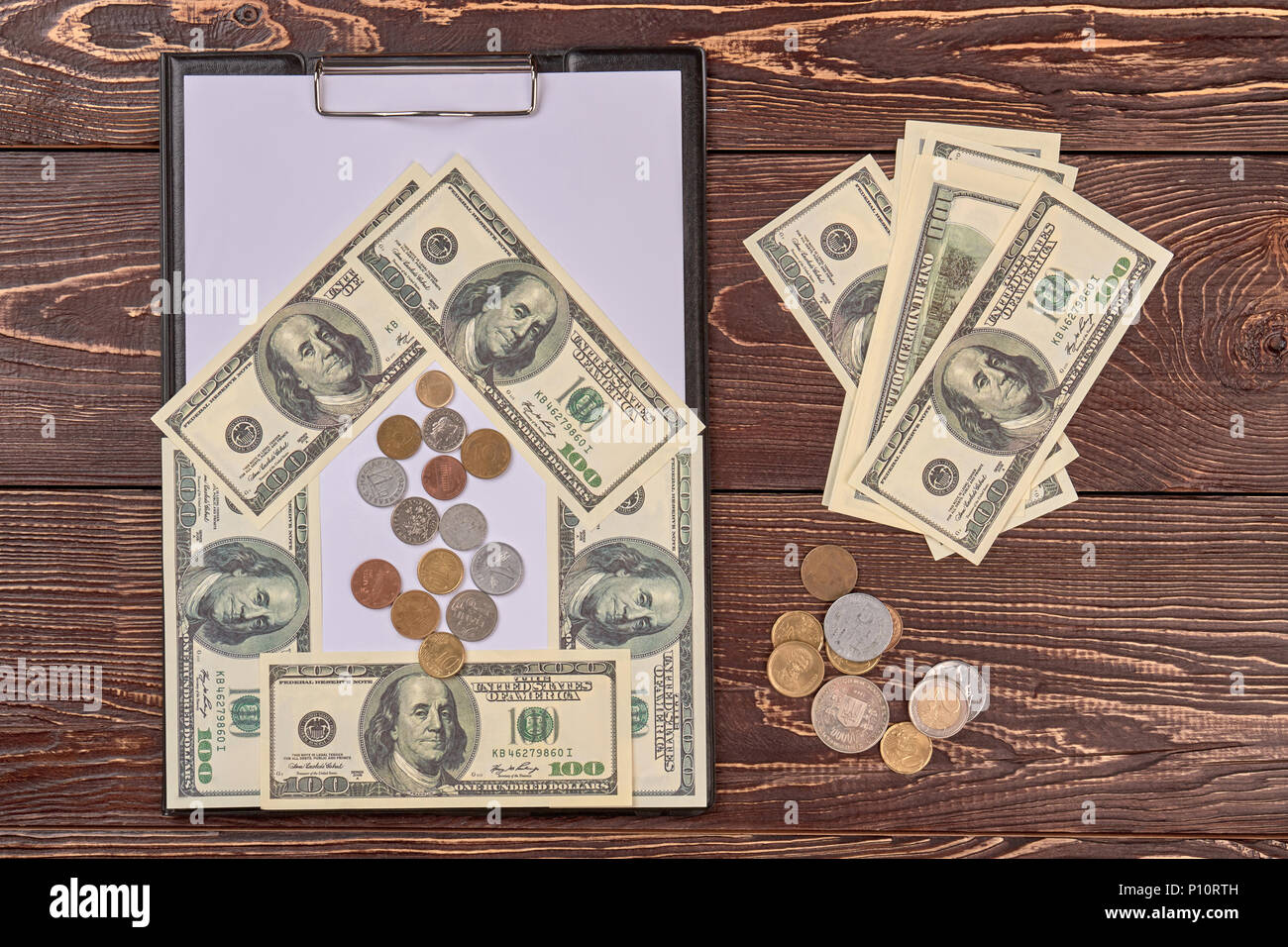Appunti nero vuota con un foglio di carta di dollari americani in contanti. Vista superiore, piatto laici. Scrivania in legno sfondo. Foto Stock