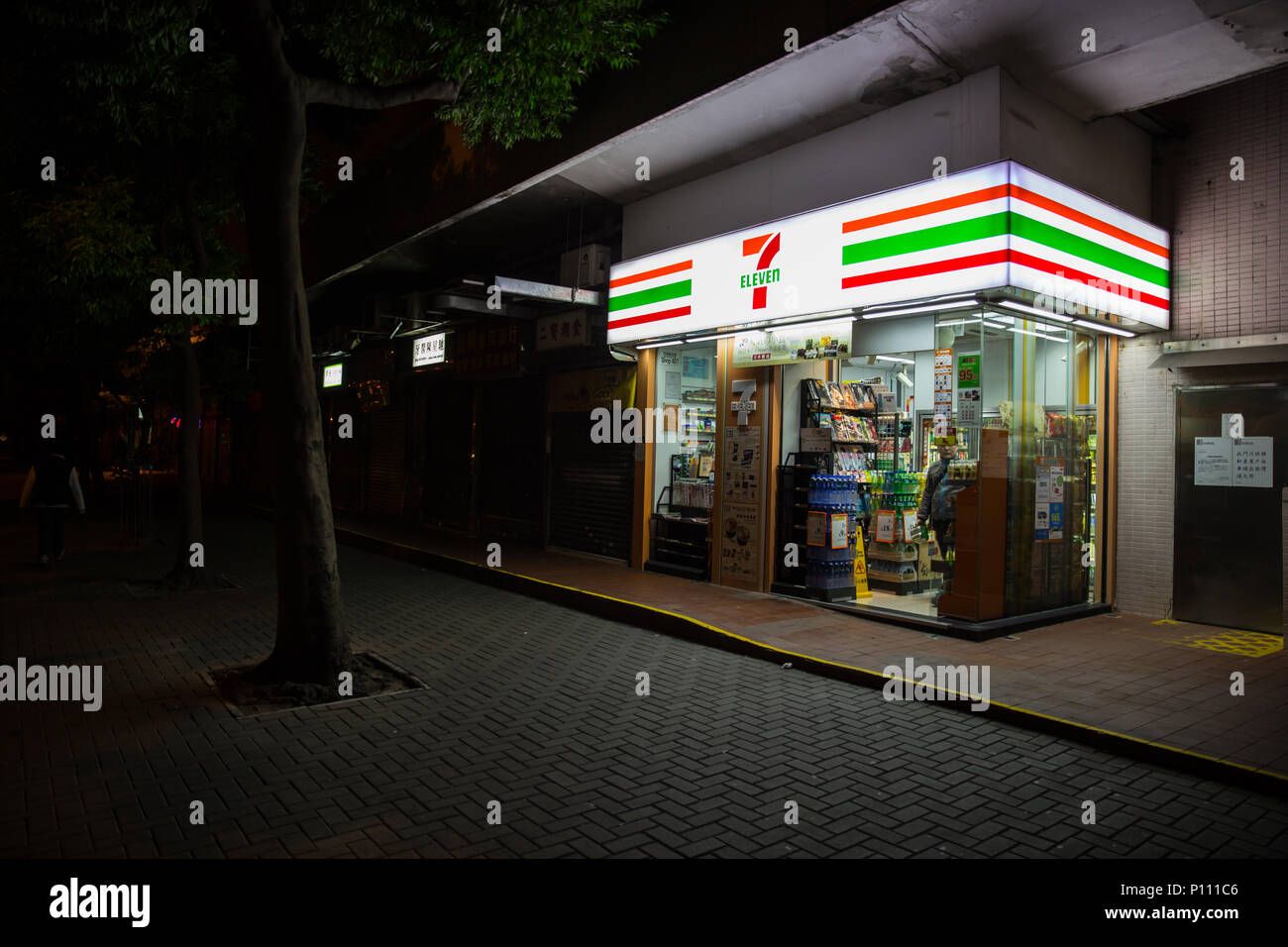 24 ore convenience store 7-11 o 7-Eleven apertura tutta la notte rendono luminosa strada di notte e la sicurezza di Hong Kong. Il 24 novembre 2017. Foto Stock