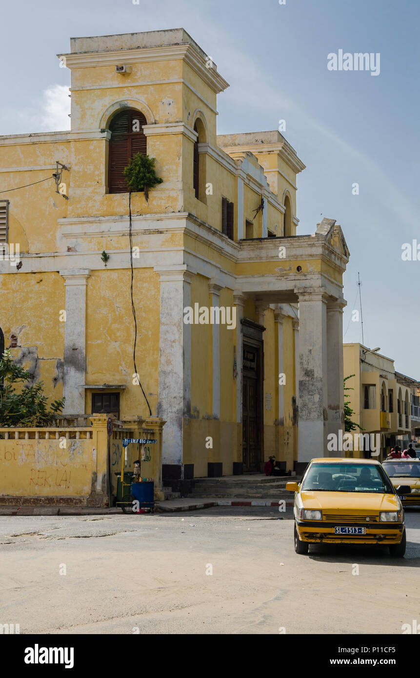 Allo sbiadimento giallo edificio coloniale e la strada con il taxi in città di San Luigi Foto Stock