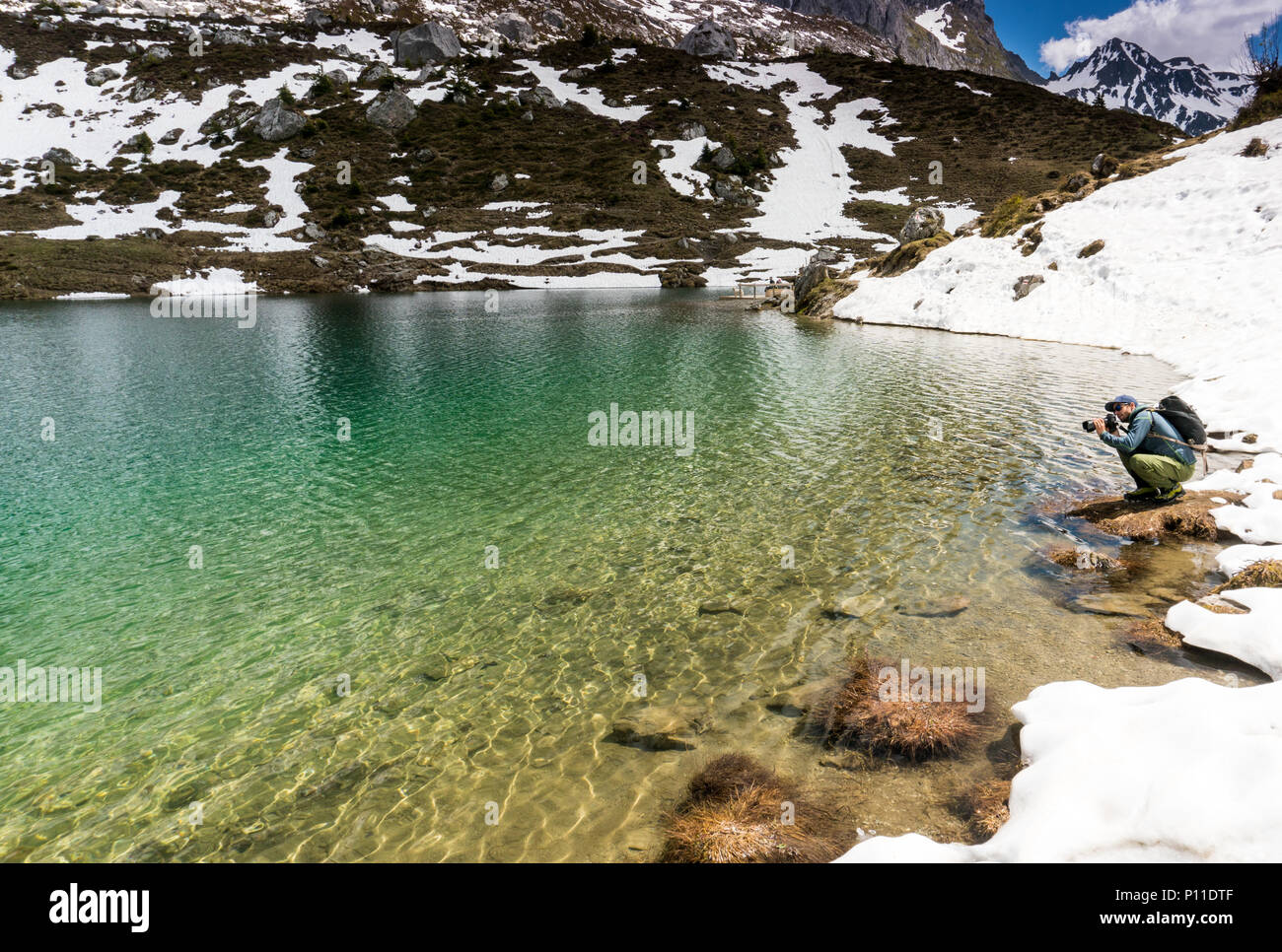 Paesaggio maschio fotografo lavorando sulla posizione su una ripresa nelle Alpi Svizzere vicino a Klosters Foto Stock