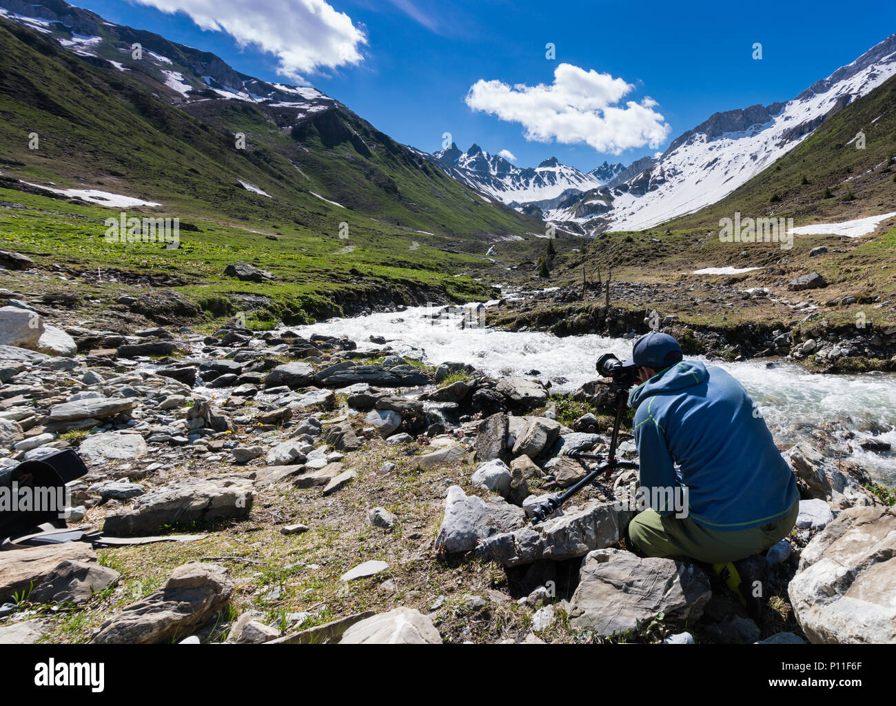 Paesaggio maschio fotografo lavorando sulla posizione su una ripresa nelle Alpi Svizzere vicino a Klosters Foto Stock