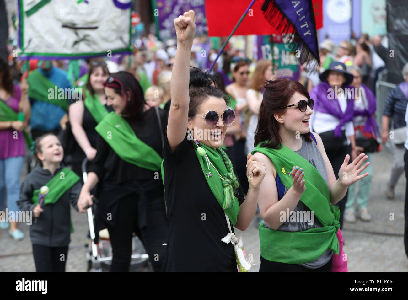 Donne marzo a Belfast, Irlanda del Nord vestito di verde, viola e bianco - i colori del movimento delle Suffragette - per celebrare i cento anni le donne sono state concesse alla votazione. Foto Stock
