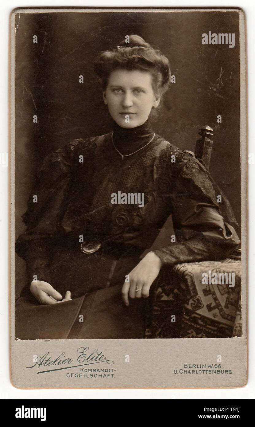 Berlino, Germania - circa 1895: cabinet Vintage carta mostra donna con Vittoriano e Edwardian capelli stile siede a tavola. Antico bianco nero photo. Foto Stock