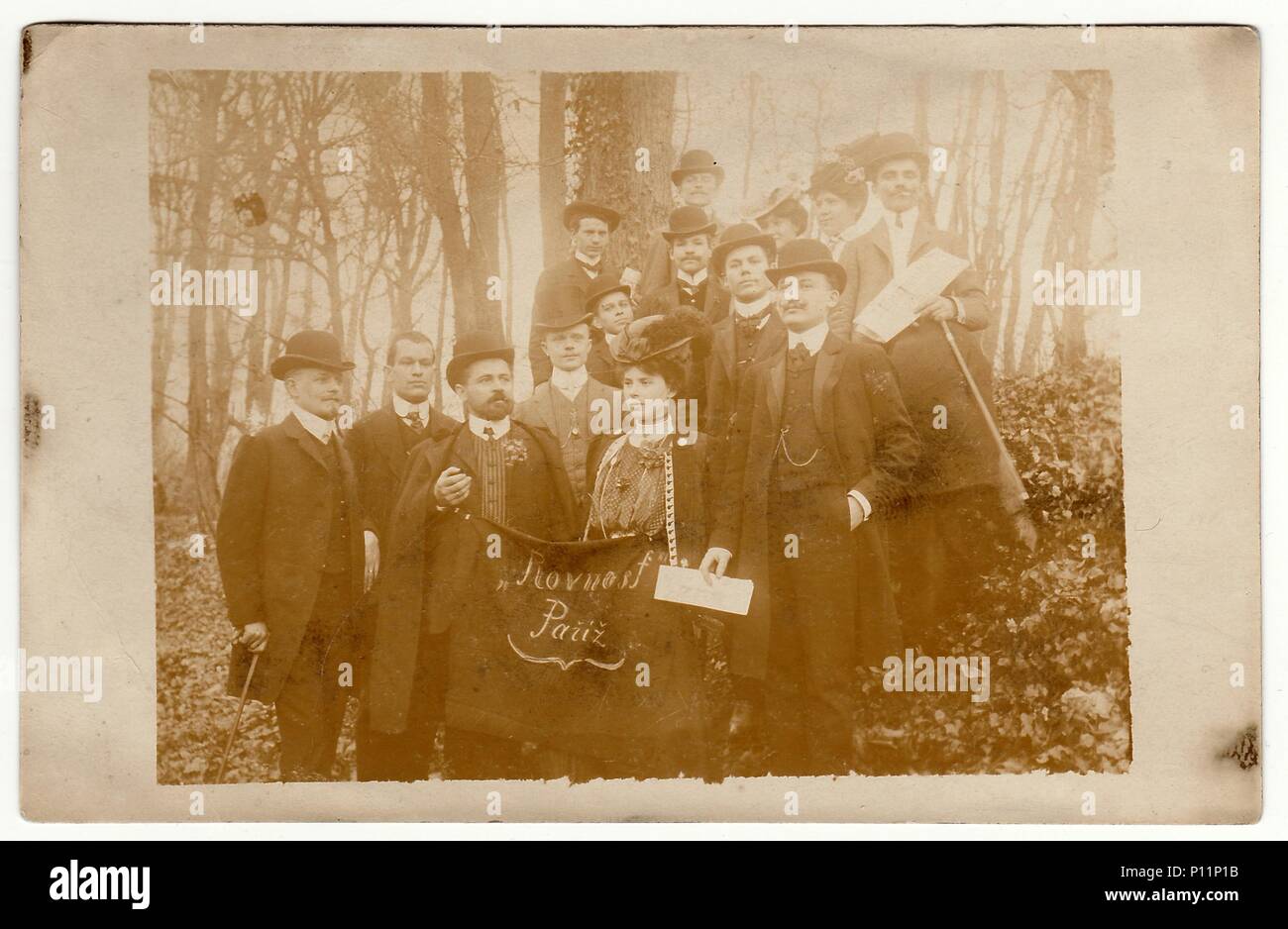 Parigi, Francia - circa novecento: Vintage la foto mostra il gruppo di persone - Repubblica Ceca i patrioti in Francia. In prima linea uomo e donna tenere standard con testo in ceco: Uguaglianza Pariz. Foto Stock