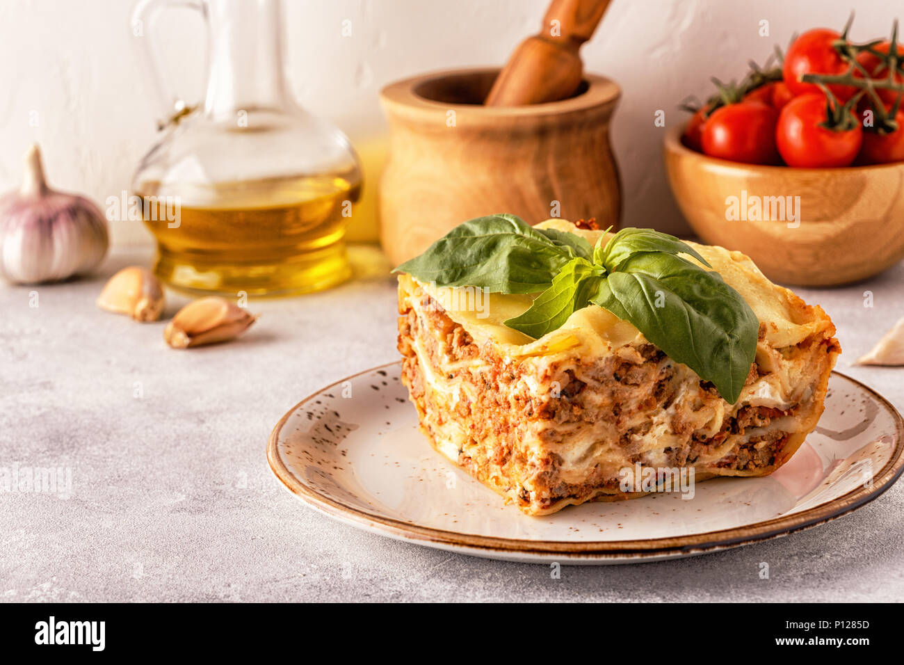 Lasagne tradizionali realizzati con le carni bovine macinate ragù alla bolognese e besciamella guarnita con foglie di basilico. Foto Stock