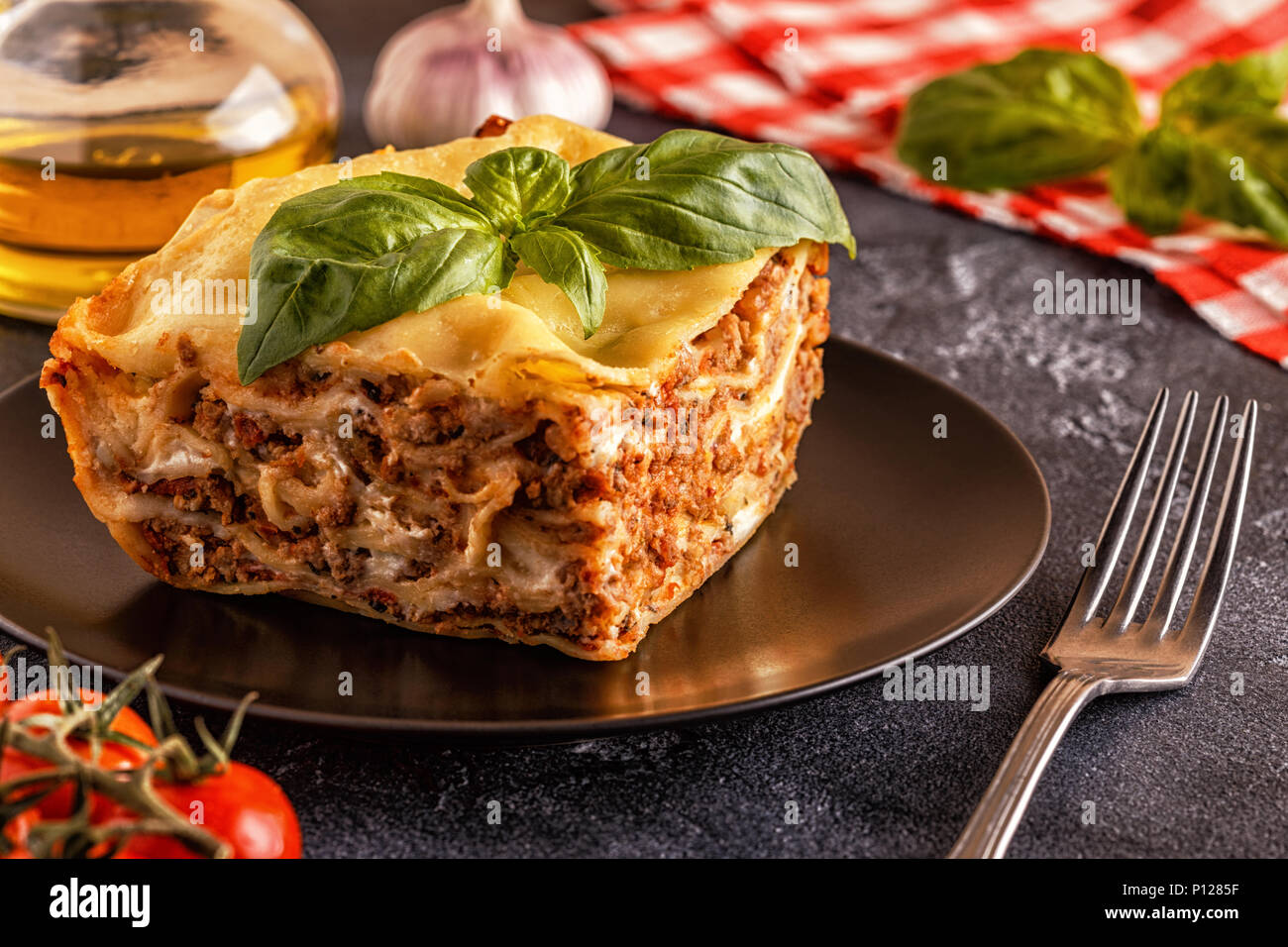 Lasagne tradizionali realizzati con le carni bovine macinate ragù alla bolognese e besciamella guarnita con foglie di basilico. Foto Stock