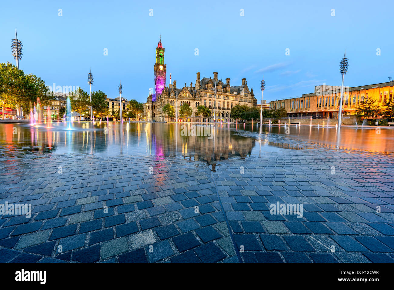 Ampia piscina a specchio schizzato da 107 fontane ora risplende accanto al Victorian city hall, Bradford, Regno Unito Foto Stock