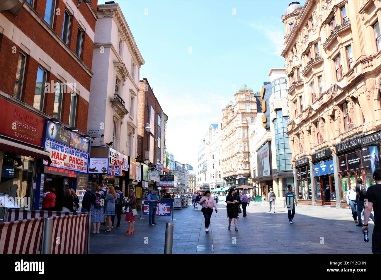 Leicester Square / St Martin's Court area di Londra, UK che mostra la gente camminare intorno al sole. Il teatro e la zona di turismo. Foto Stock